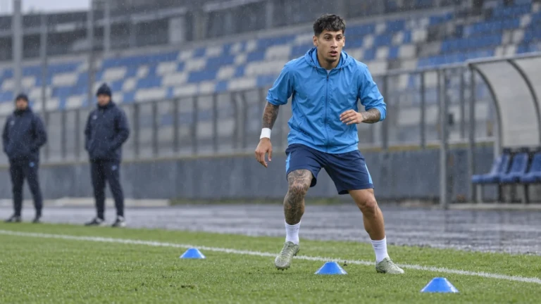 Mathias Olivera tập di chuyển ngang trên sân tập trong mưa nhẹ